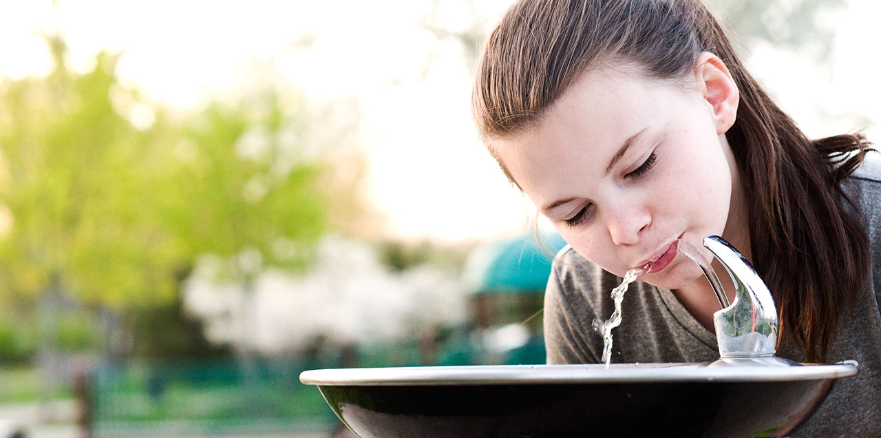 Girl drinking from water fountain