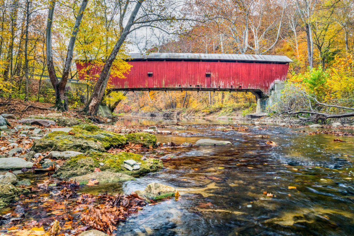 Built in 1915, the Rolling Stone Covered Bridge crosses a Putnam County Indiana stream in autumn.